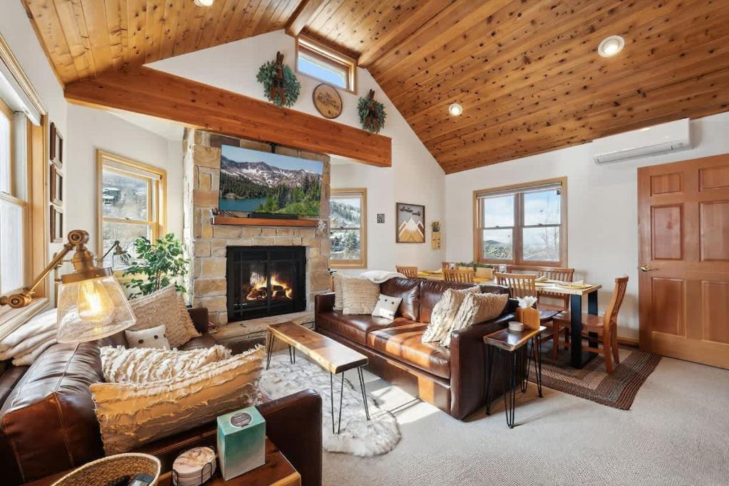 a living room with leather couches and a fireplace at Cozy Hillside Cottage Overlooking Main Street in Park City
