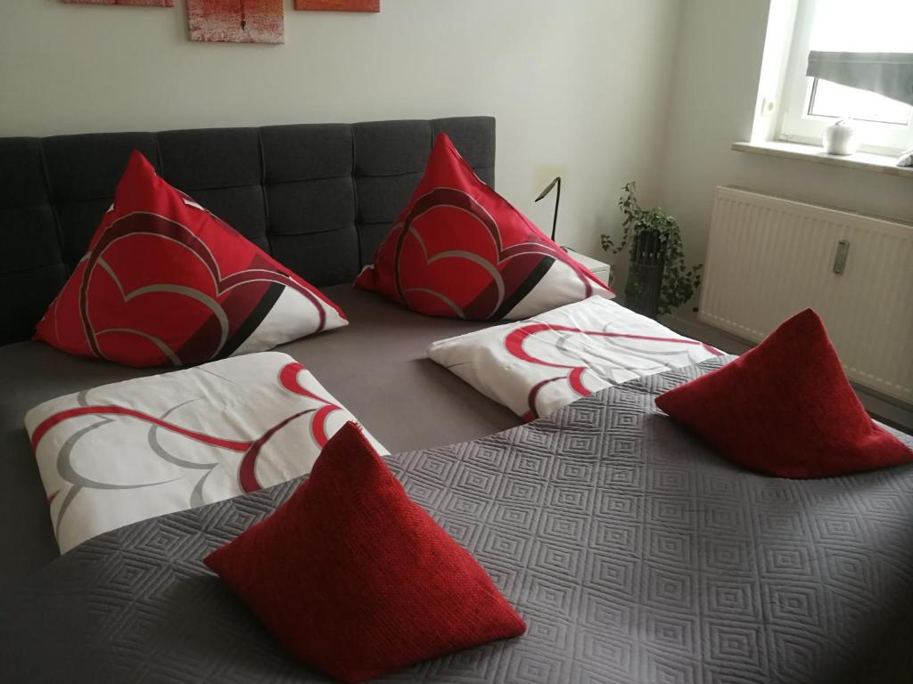 two beds with red and white pillows on them at Lindenblüte in Seehausen