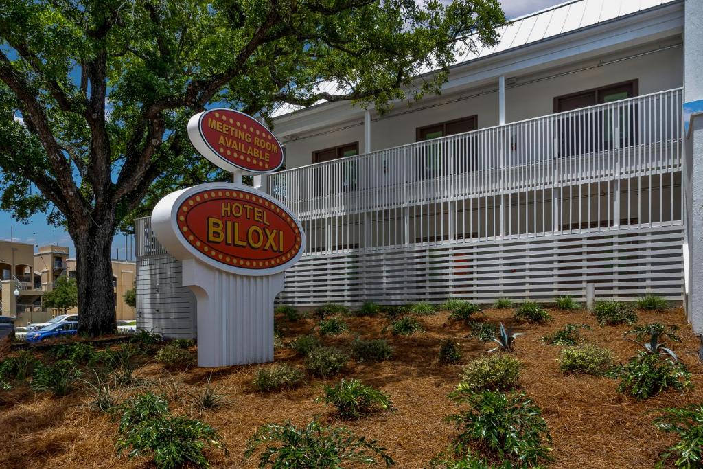 a sign in front of a house with a building at Hotel Biloxi in Biloxi