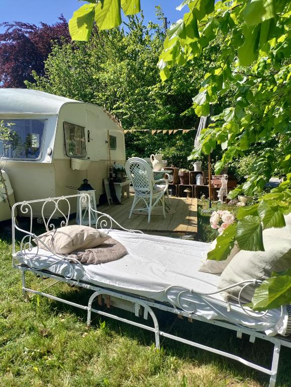 a bed in the grass next to an rv at The running Rabbit caravan in Ystad