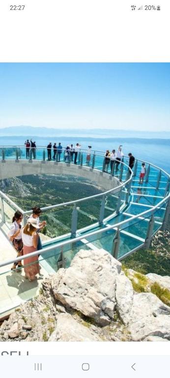 a group of people standing on an observation deck overlooking the ocean at Kuća za odmor Virgo in Opanci