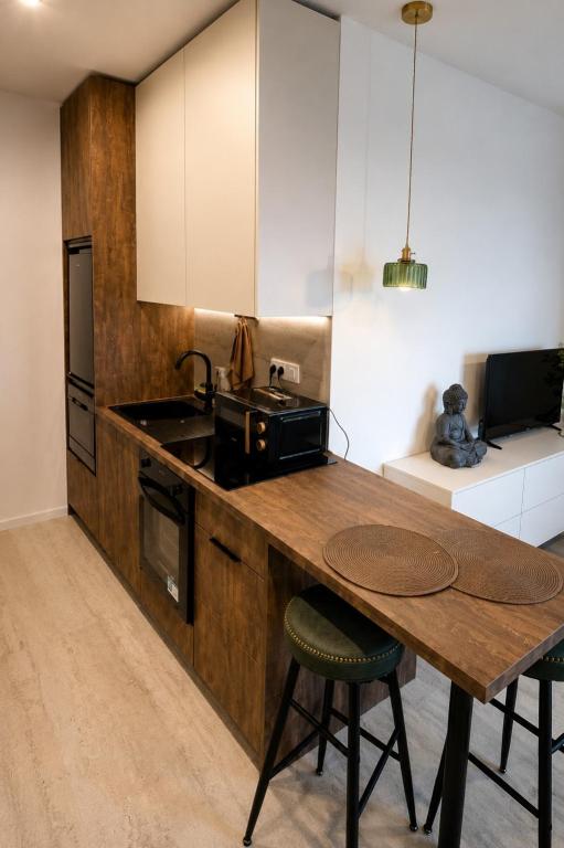 a kitchen with a wooden counter top and a table at Apartmán na Rohu II in Malacky