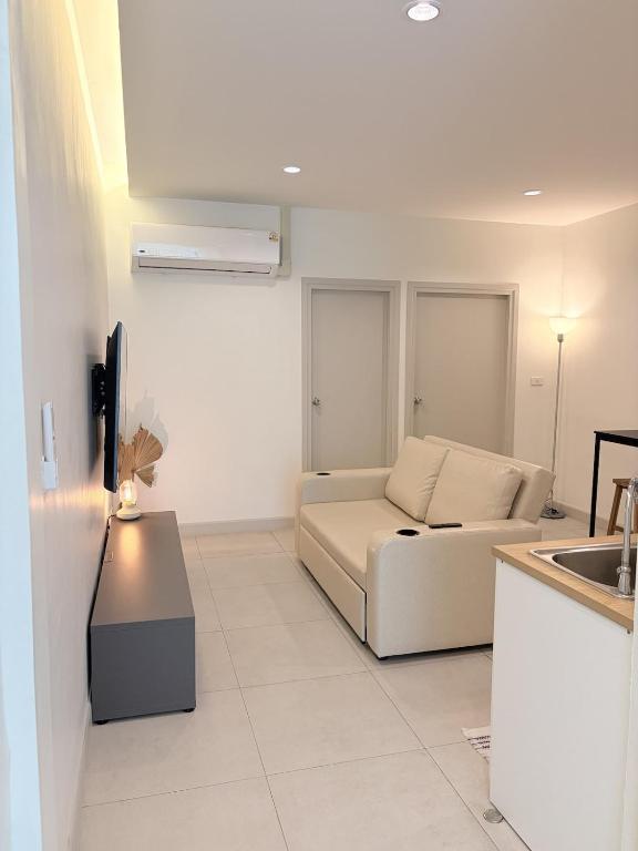 a white living room with a couch and a table at 2 Bed & 2 Bath Suite, 5th floor in Ban Bang Toei (1)