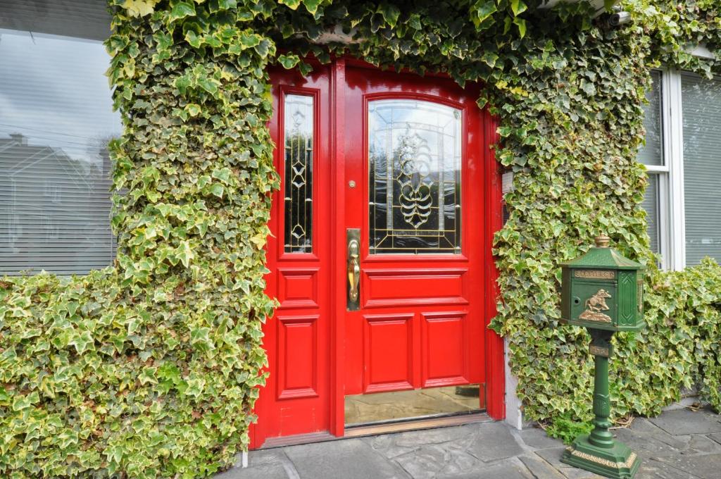 eine rote Tür an der Seite eines Gebäudes in der Unterkunft Ash Grove House in Galway