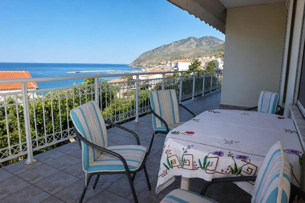 a balcony with a table and chairs and the ocean at Sea view apartment in Plomari