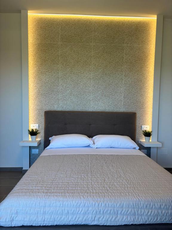 a bedroom with a large bed with a large headboard at Linea d Orizzonte in Francavilla al Mare