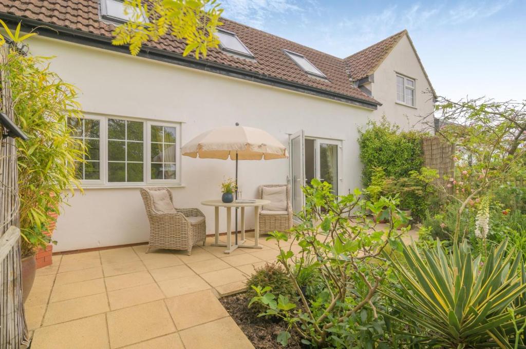 a patio with a table and chairs and an umbrella at 1 Bed in Taunton oc-75135 in Isle Brewers