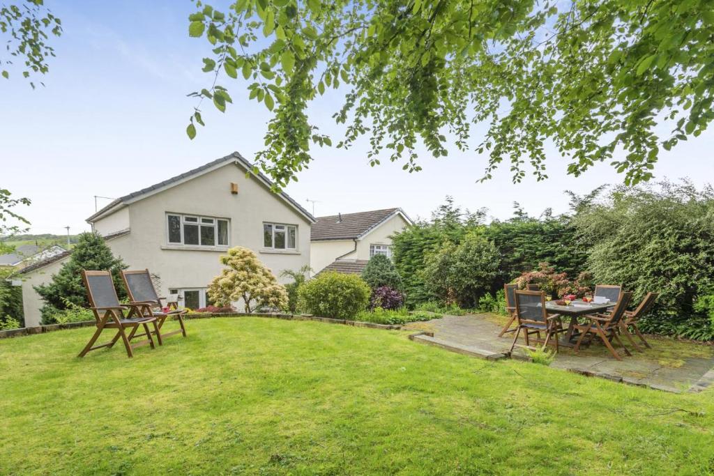 a garden with a table and chairs in front of a house at 4 Bed in Ilkley oc-ds168 in Ilkley