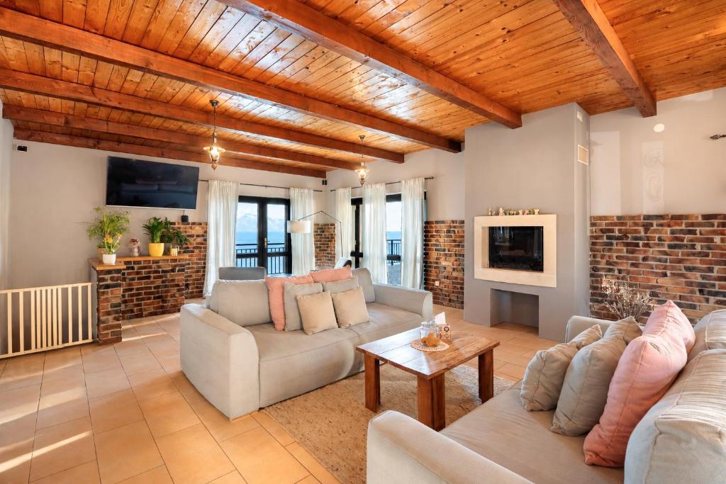 a living room with couches and a brick wall at Galeb Bed and Breakfast in Baćina