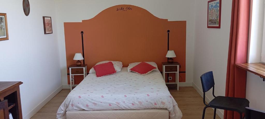 a bedroom with a large bed with two red pillows at La Maison d'Osquich in Musculdy