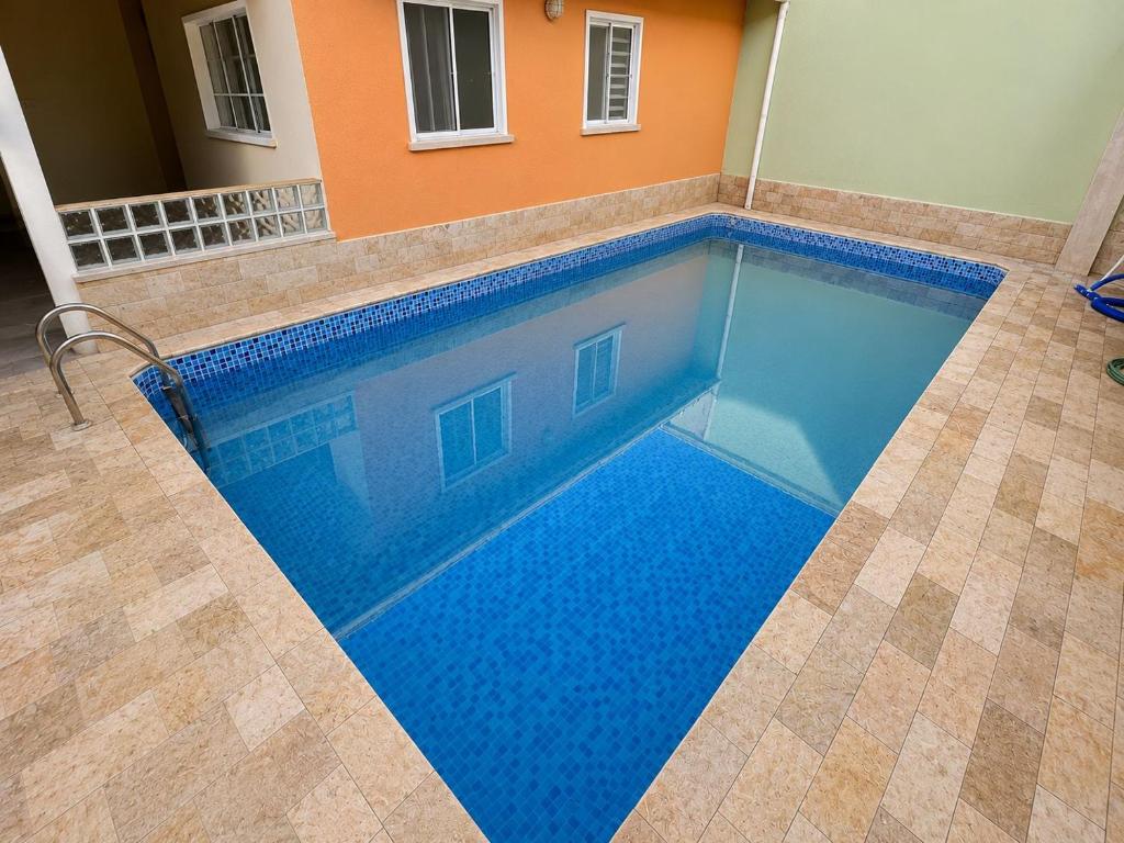 a swimming pool with blue water in a house at Hospedaria Campinas in Campinas
