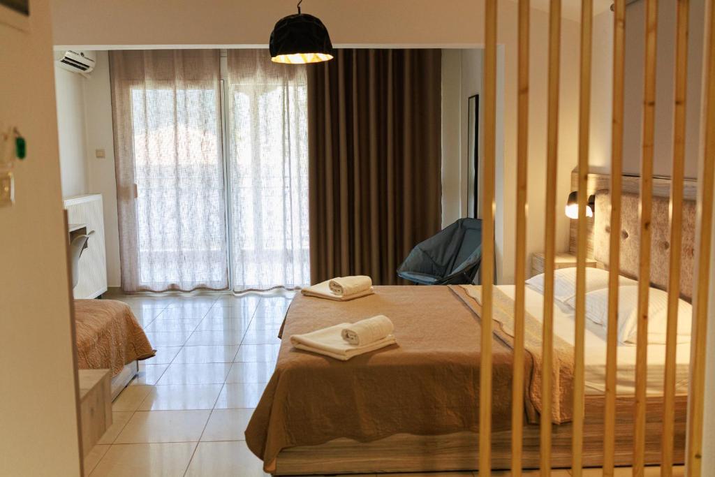a bedroom with a bed in a room with curtains at Studios Denis in Stavros