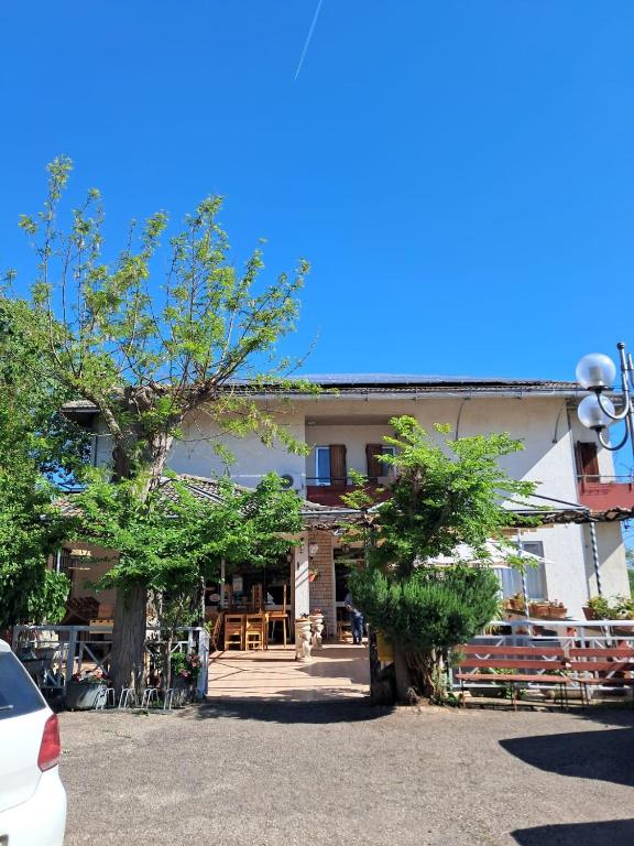 a white building with trees in front of it at Albergo Ristorante Il Torrione in Auditore