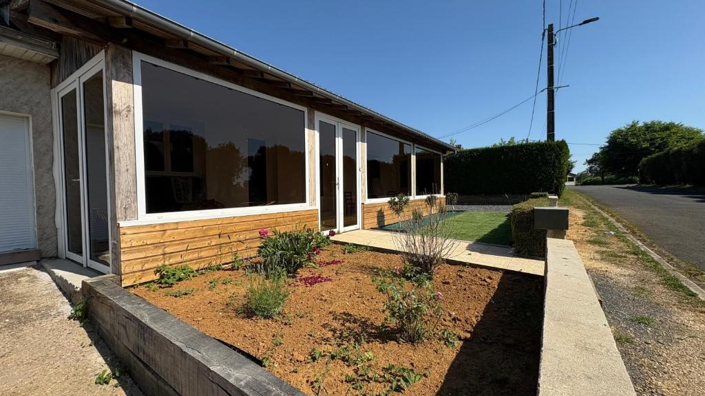 a house with a garden in front of it at Gite Les Pivoines in Saint-Robert