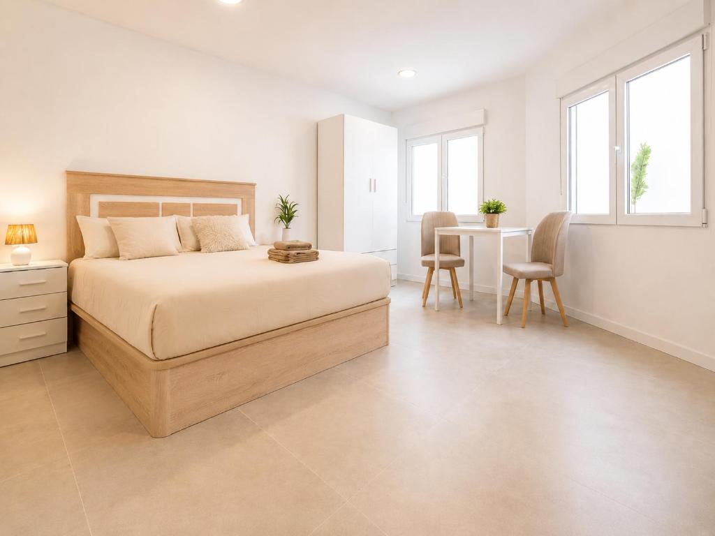 a bedroom with a bed and a table and chairs at Sanchis Studios in Alicante