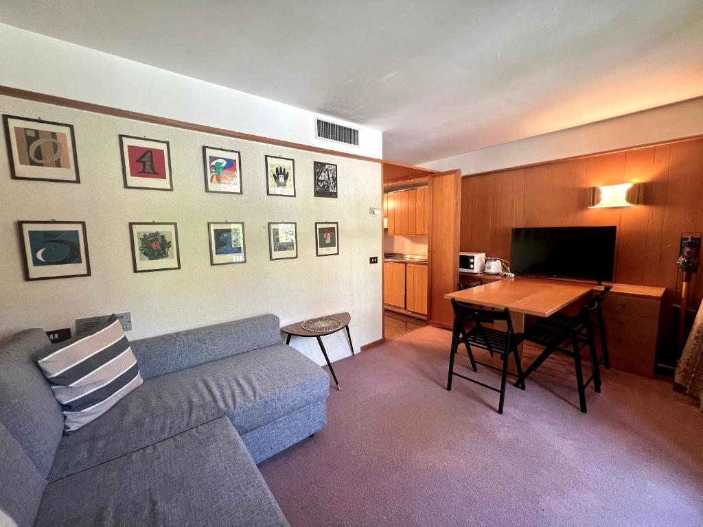 a living room with a couch and a table at Monolocale Des Alpes 204 in Madonna di Campiglio
