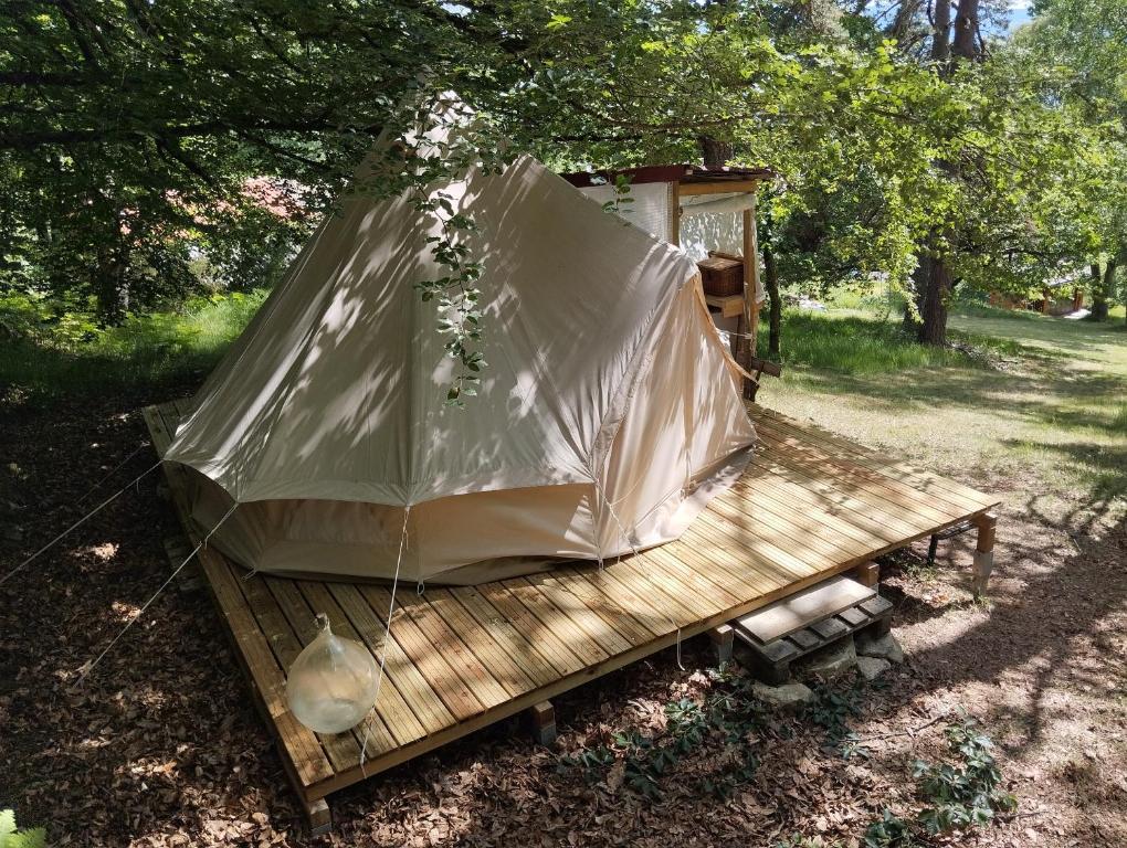 a tent sitting on a wooden platform in a field at La Ramie in Marat