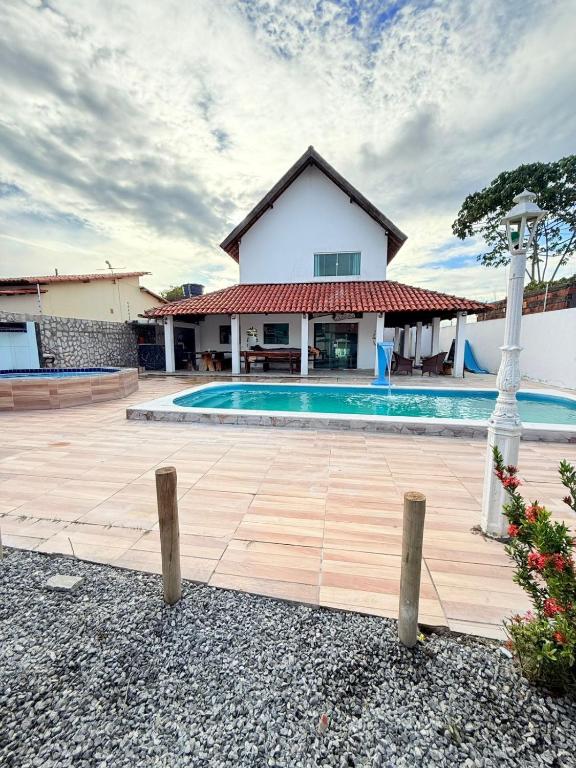 a villa with a swimming pool and a house at casa em jacumã in Conde