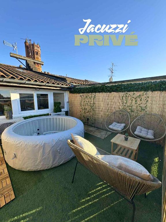 a backyard with a large tub and two chairs at La Bulle Secrète in Villeneuve-sur-Lot