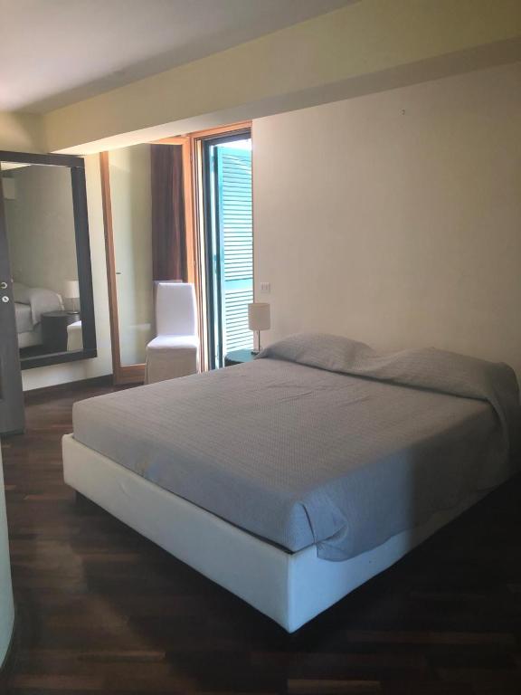 a bedroom with a bed and a chair and a window at Casavacanze da Mari in Tivoli Terme