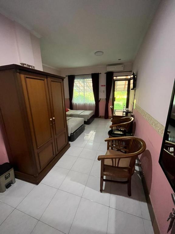 a living room with a couch and a table and chairs at Wisma Pakuan Syariah Hotel in Bogor