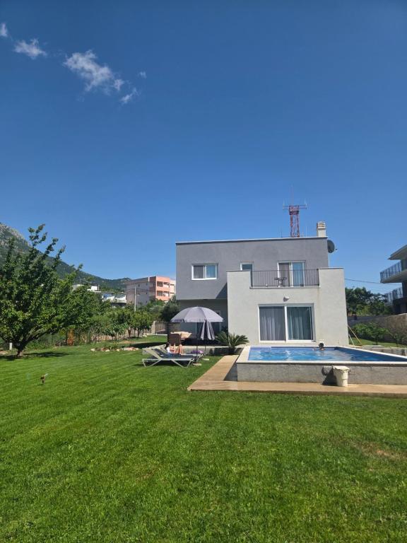 a house with a swimming pool in front of a yard at Villa Oaza in Bar