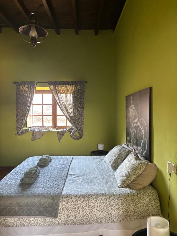 a bedroom with a large bed with a window at Casona La Orilla 1908 Tías in Tías