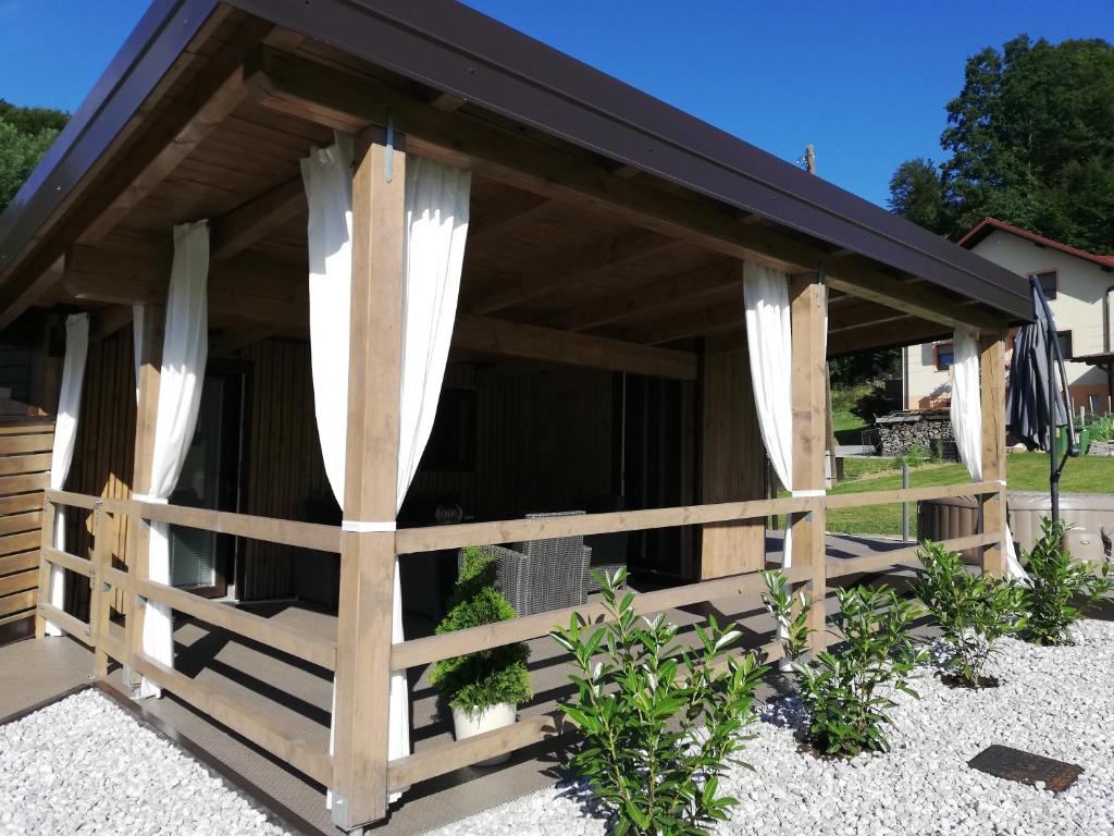 a wooden building with curtains and a fence at Apartma Dečko Rogaška in Rogaška Slatina