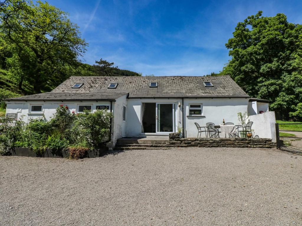 a cottage with a table and chairs in front of it at Daffodil Cottage in Treorky