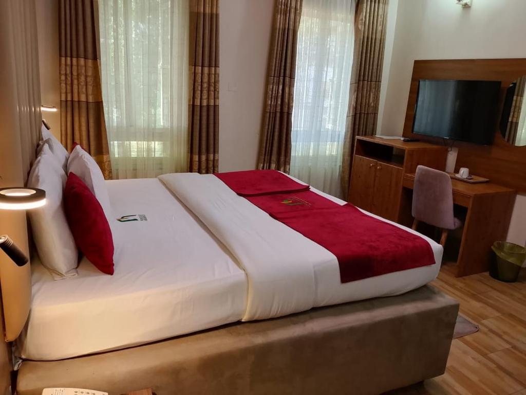 a bedroom with a large bed and a television at Marrisson Residence in Abuja