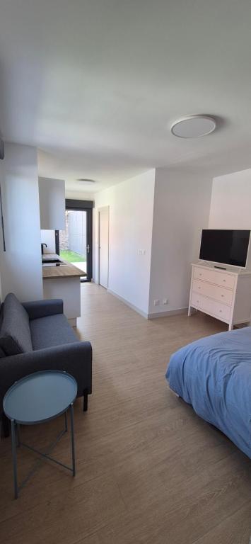 a bedroom with a bed and a couch and a desk at Studio between city and countryside in Lompret