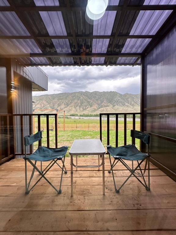 two chairs and a table on a porch with a view at Пан0рама in Saty