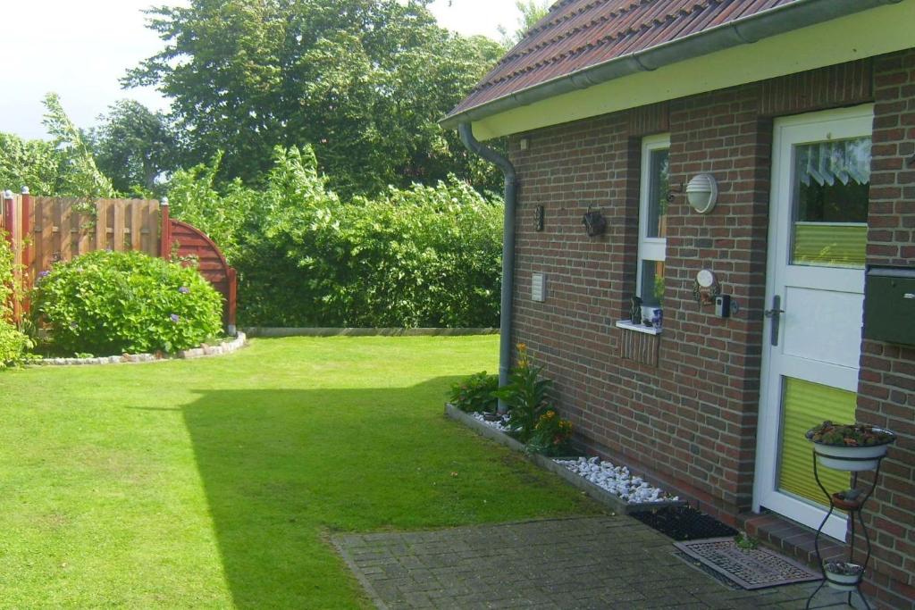 a yard with a brick house with a door at Haus Deichbrise in Niebüll