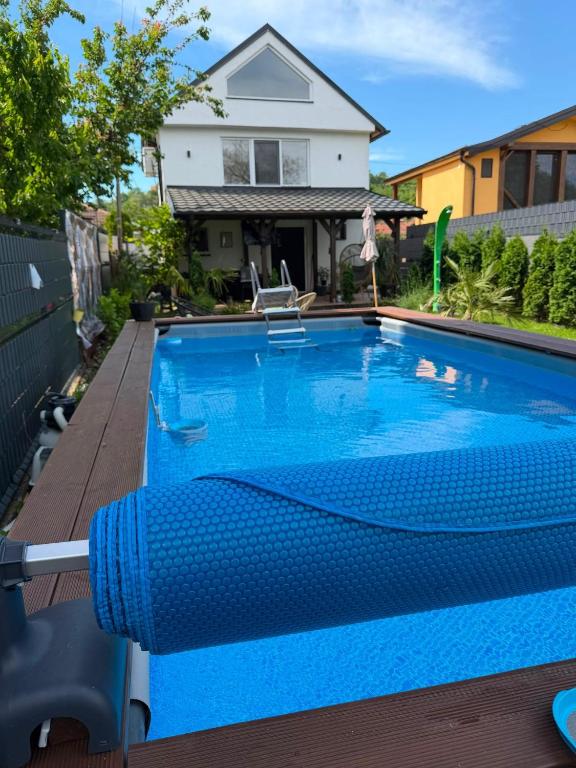 a blue swimming pool with a house in the background at Elephant House-Sd in Seone