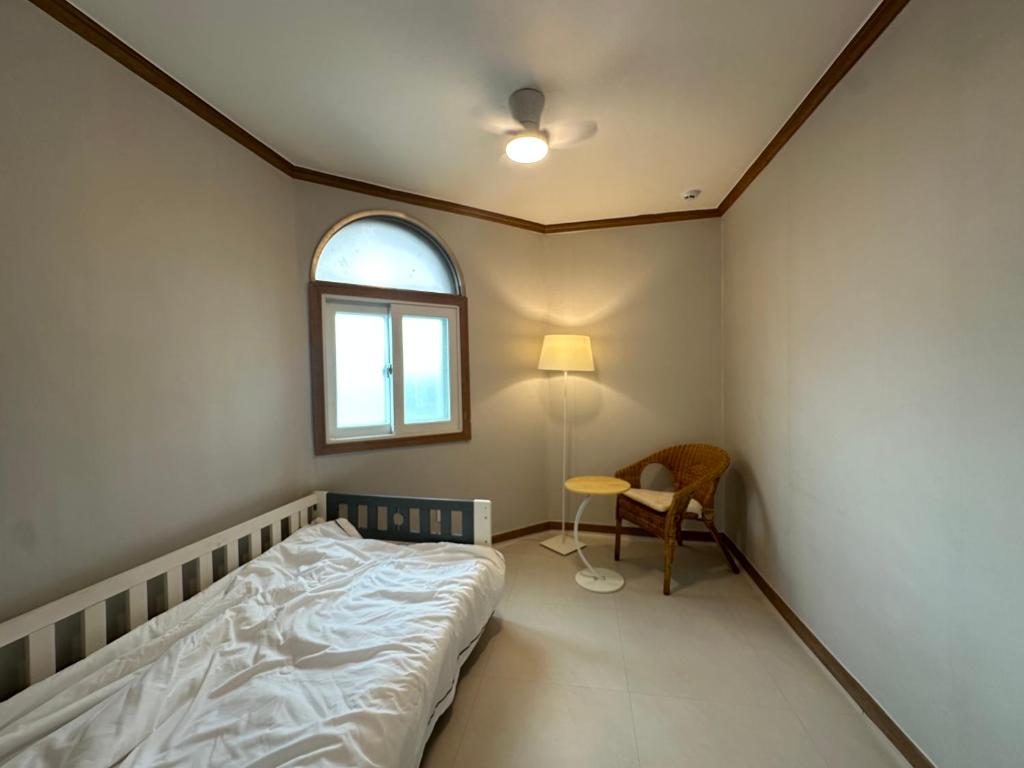 a bedroom with a bed and a window and a table at Lagom villiage in Paegun-dong