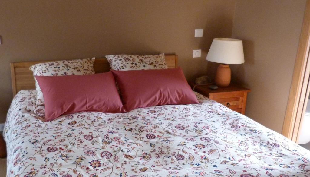 a bed with two pink pillows on top of it at Mas des Treilles - Chambre d'hôtes - Côté Campagne in Mane