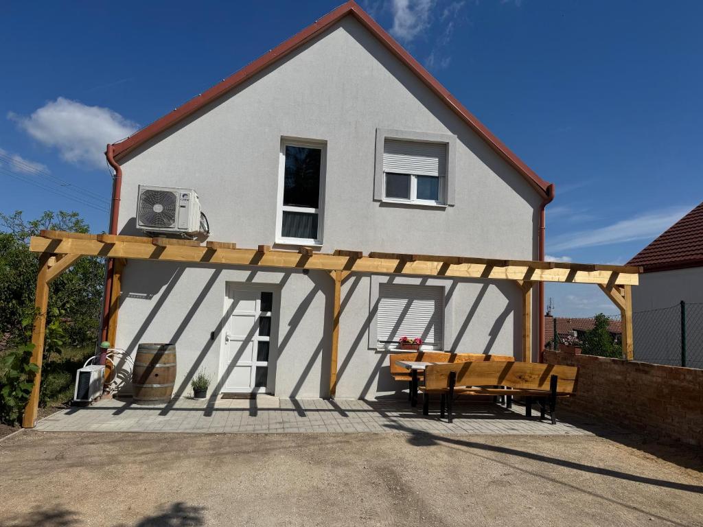 a house with a pergola and a table and bench at Ubytování Pod Mezu in Hlohovec
