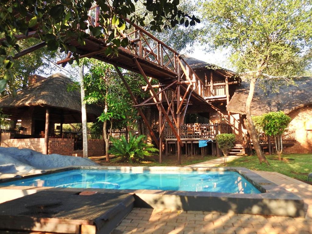 a resort with a swimming pool and a house at Bona Ngwenya Lodge & Safaris in Marloth Park