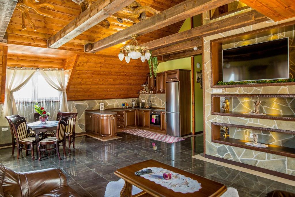 eine Küche und ein Esszimmer mit einem Tisch und Stühlen in der Unterkunft The Golden Eagle in Tatranská Kotlina