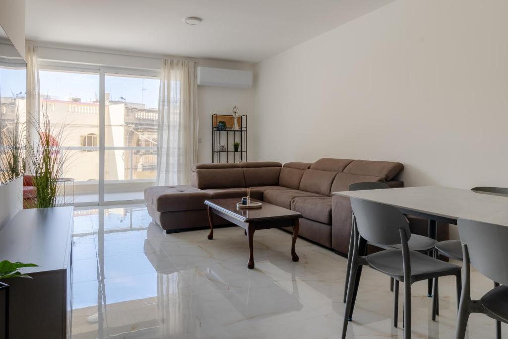 a living room with a couch and a table at Three Bedroom Qormi Home in Santa Venera