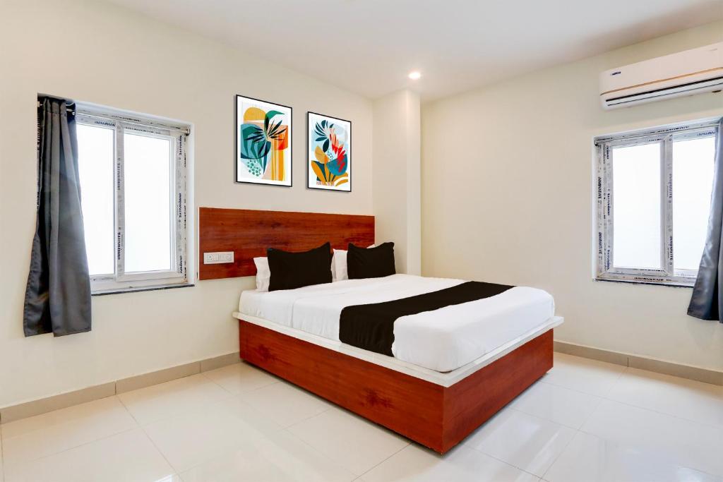 a bedroom with a bed and two windows at Super Hotel O RB Classic Inn in Kottapalli