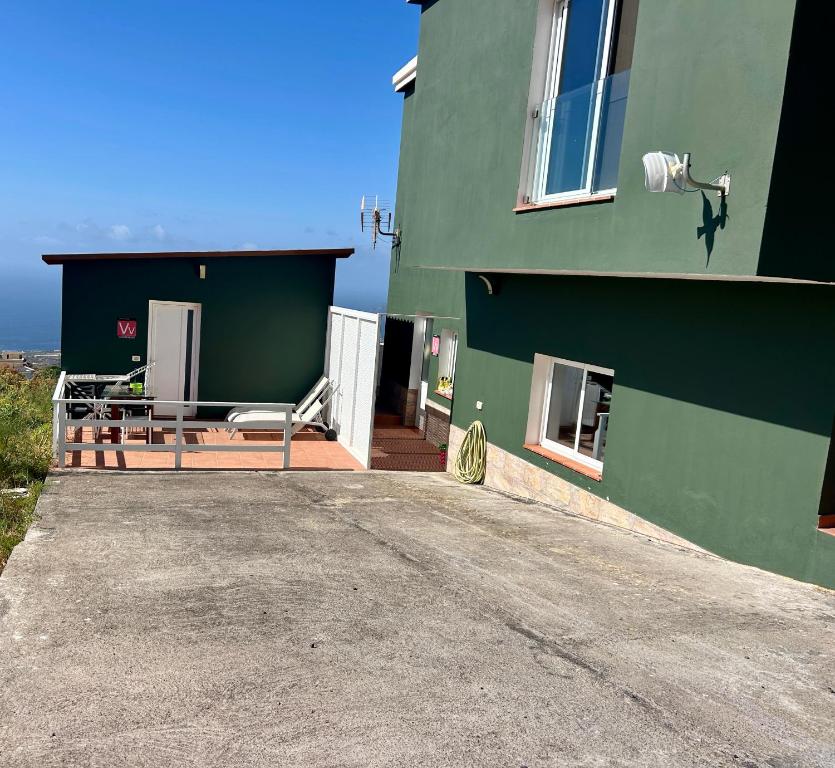 a green building with a table and chairs outside at Las Toscas in Frontera