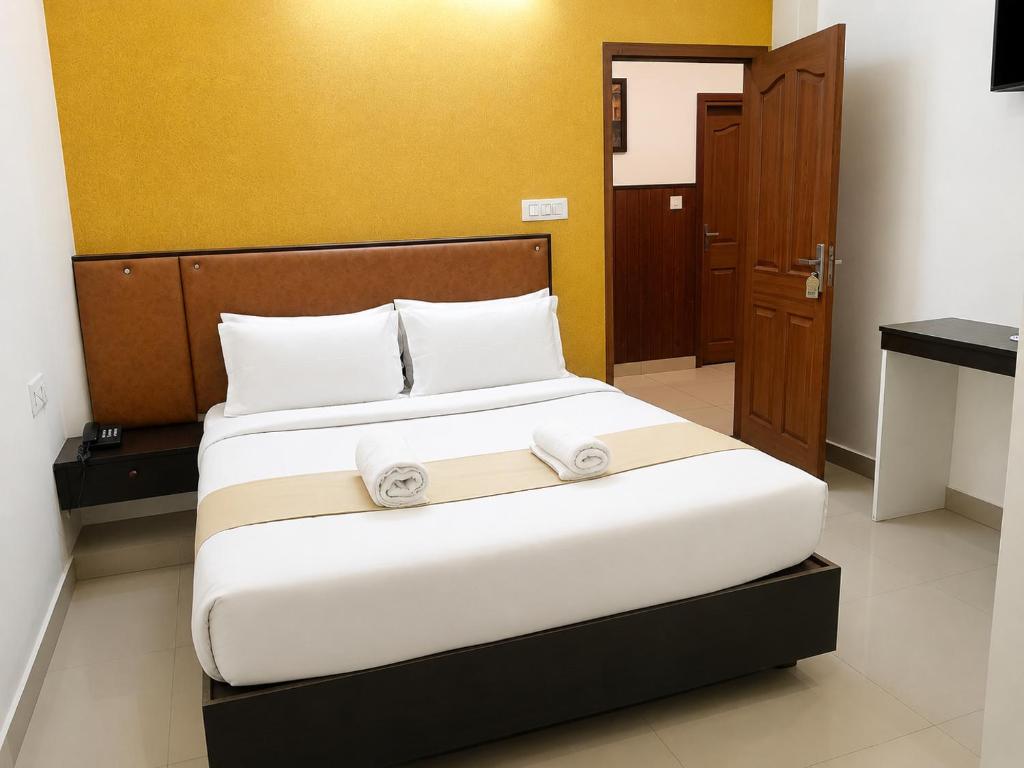 a bedroom with a bed with two white pillows at Nova North Inn in Cochin
