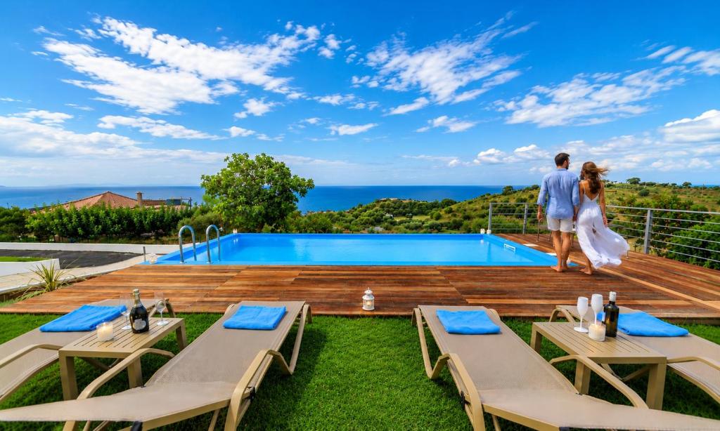 a bride and groom standing on the deck of a villa at Georgioupolis Blue Villa in Georgioupolis
