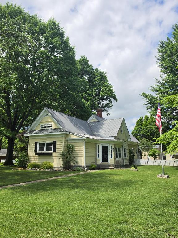 a white house with a flag in a yard at Derby Dreams llc in Clarksville