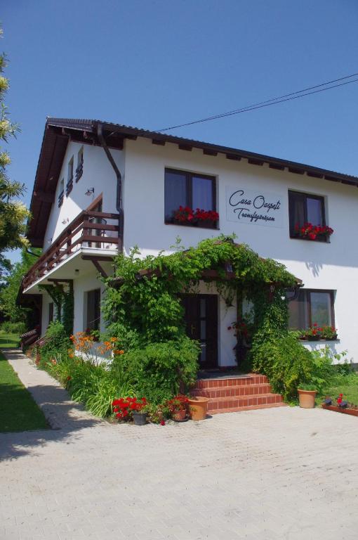 a white building with flowers in front of it at Casa Oaspeti Transfagarasan in Cârțișoara