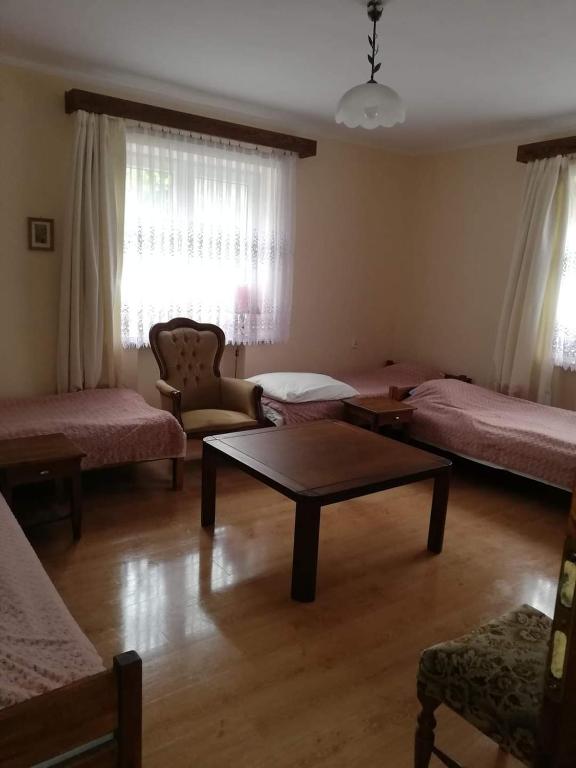 a living room with beds and a coffee table at Pokoje Augustów 5 osobowy i 3 osobowy in Augustów