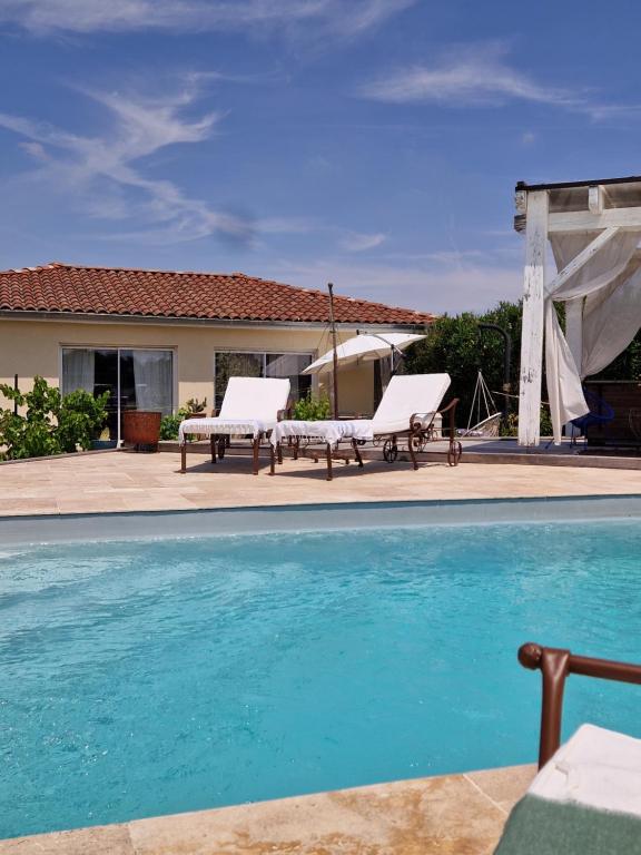 a swimming pool with two benches and a house at Casa Brens in Brens