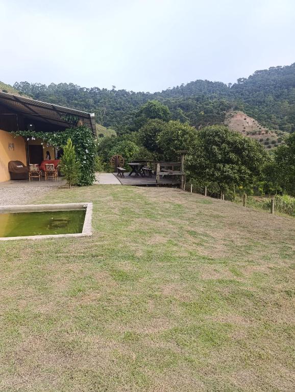 a large yard with a picnic table and a house at Pousada Pindobas in Venda Nova do Imigrante