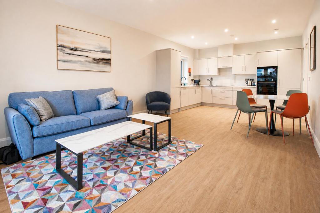 a living room with a blue couch and a kitchen at The Maltings in Portlaoise